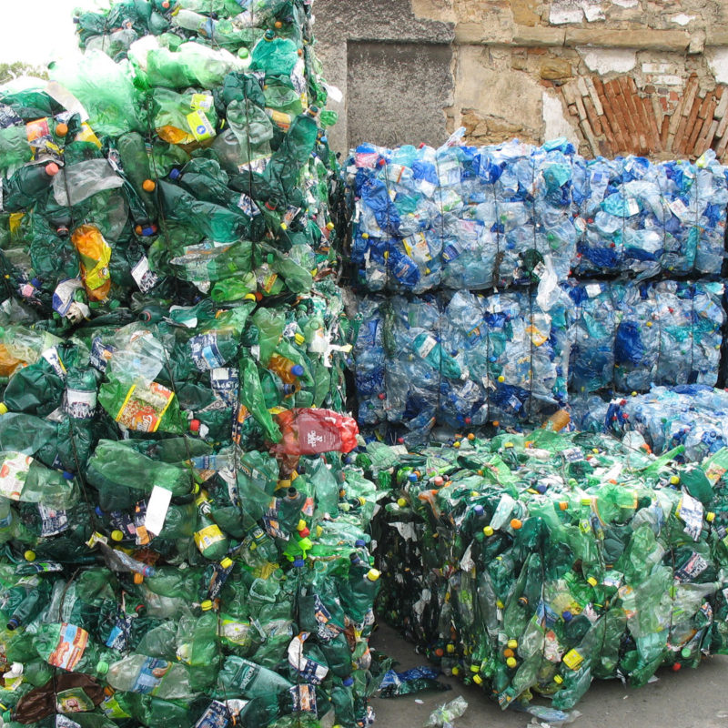 Balíky zelených a modrých PET lahví určené k přepravě na zpracování.